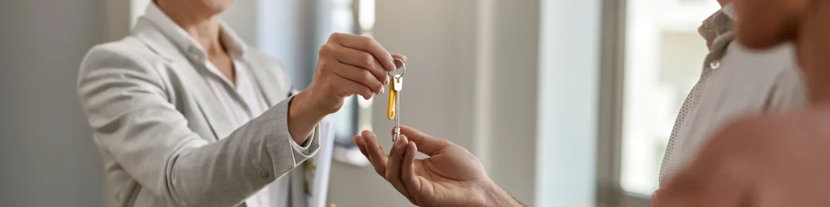 happy-real-estate-agent-giving-couple-keys-their-new-home (1)